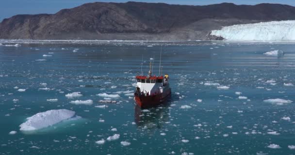 4k Video della barca da pesca rossa groenlandese che attraversa Disko Bay, Groenlandia. Ghiacciaio sullo sfondo e iceberg nell'acqua blu dell'oceano. Eqip Sermia Glacier Eqi vicino alla città artica di ilulissat . — Video Stock