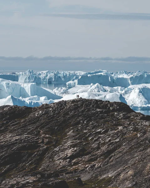 Északi-sarkvidéki táj jéghegyekkel Grönland jéghegyén, éjféli napnyugtakor a láthatáron. Kora reggeli alpenglow az éjféli szezonban. Ilulissat, Nyugat-Grönland. — Stock Fotó