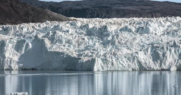 4k移動タイムラプスグリーンランドのエキップセルミア氷河Eqi氷河のビデオクリップは、カルビング氷河と呼ばれる。氷の巨大な氷河の壁。氷の大きな塊が落ちる。ポート・ビクターの近くだハイカー — ストック動画