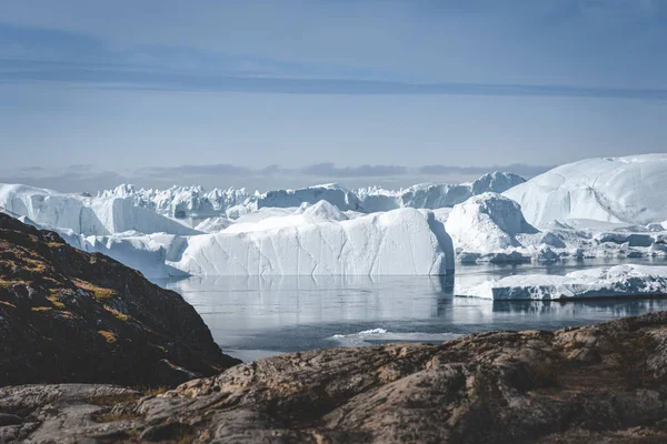 Paisagem natural do Árctico com icebergs no fiorde de gelo da Gronelândia com sol da meia-noite nascer do sol no horizonte. Alpenglow de verão de manhã cedo durante a temporada da meia-noite. Ilulissat, Gronelândia Ocidental. — Fotografia de Stock