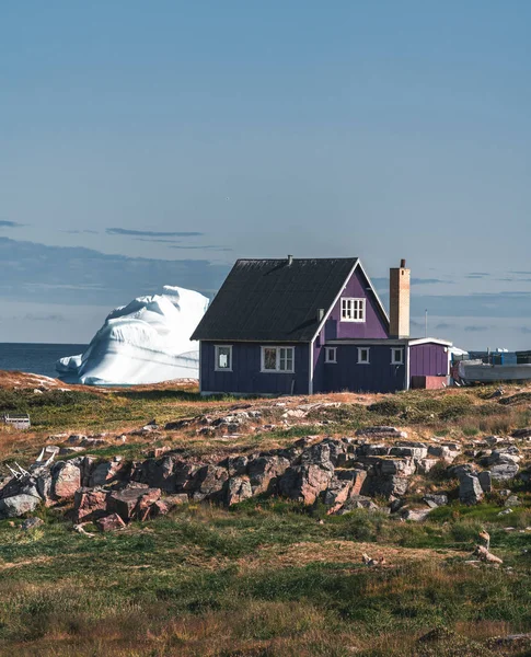 Типовий дерев'яний будинок рибалок з айсбергом в Qeqertarsuaq, затоці Діско Гренландія і Ілуліссат. Типова архітектура в арктичному колі. Літо і блакитне небо. — стокове фото