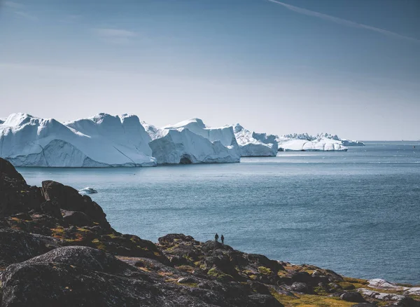 Arctic nature landscape with icebergs in Greenland icefjord with midnight sun sunset sunrise in the horizon. Early morning summer alpenglow during midnight season. Ilulissat, West Greenland. — Stock Photo, Image