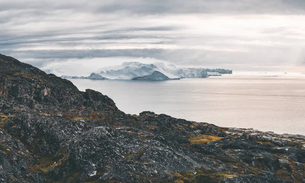 Arktiskt naturlandskap med isberg i Grönlands isfjorden med midnattssoluppgång i horisonten. Tidig försommar alpenglow under midnattssäsongen. Ilulissat, västra Grönland. — Stockfoto