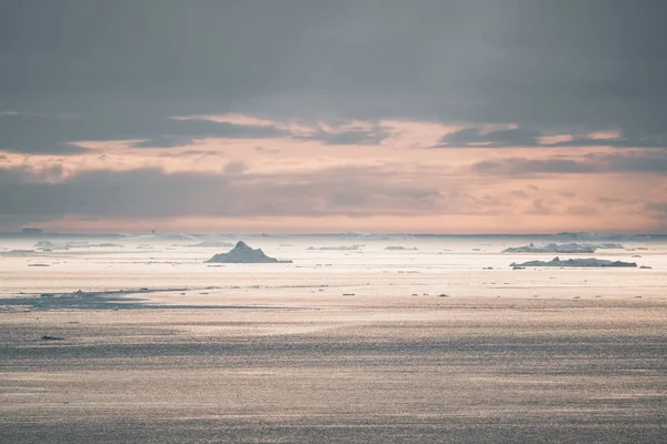 Arktická krajina s ledovci v grónském ledovci s půlnočním západem slunce na obzoru. Brzy ráno letní alpenglow během půlnoční sezóny. Ilulissat, západní Grónsko. — Stock fotografie
