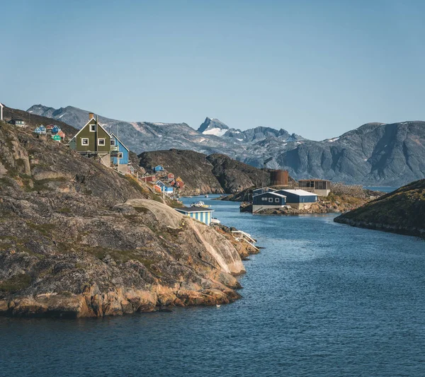 На схилах пагорбів у рибальському місті Кангааміут (Західна Гренландія) стоять барвисті будинки. Айсберги з льодовика Канджа в Гренландії плавають з блакитним небом і хмарами. Символ глобального потепління. — стокове фото