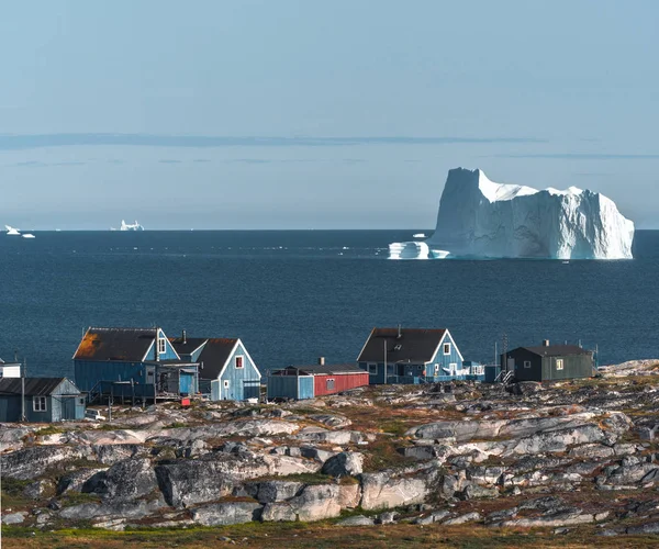 Casa tipică de pescari colorați din lemn cu aisberg în Qeqertarsuaq, zona golfului Disko Groenlanda și Ilulissat. Arhitectura tipică în cercul arctic. Vara și cerul albastru . — Fotografie, imagine de stoc