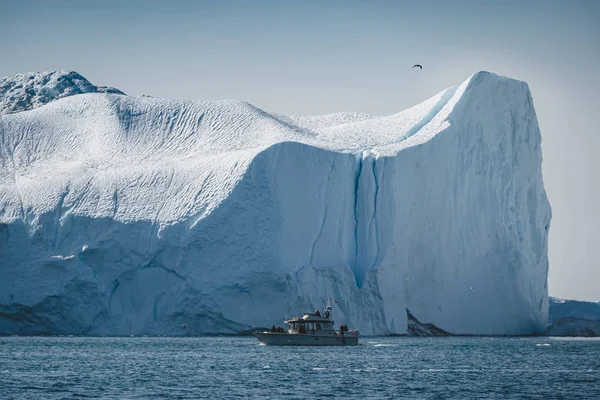 Arktiskt naturlandskap med isberg i Grönlands isfjorden med midnattssoluppgång i horisonten. Tidig försommar alpenglow under midnattssäsongen. Ilulissat, västra Grönland. — Stockfoto