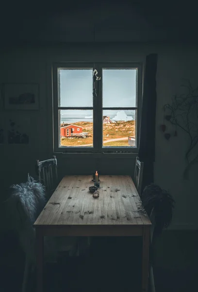 Intérieur avec table à manger et paysage arctique avec icebergs avec vue sur le soleil et la fenêtre. Nuages et reflets d'eau avec des maisons colorées . — Photo