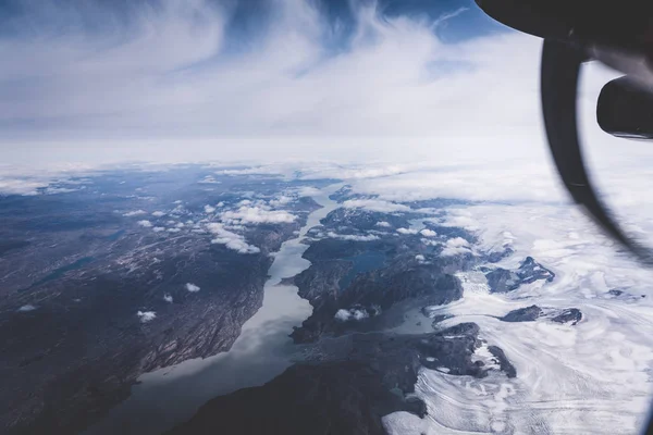 Groenlândia, vista aérea da geleira e neve coberto de montanhas. Esta é uma consequência do fenômeno do aquecimento global. A vista do avião. Foto tirada na Groenlândia . — Fotografia de Stock