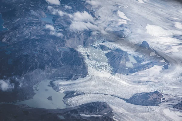 Grönland, légi kilátás gleccser és a hó borította hegyek. Ez a globális felmelegedés jelenségének következménye. A kilátás a gépről. A kép Grönlandon készült.. — Stock Fotó