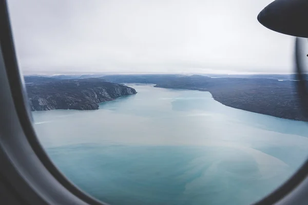 Groenlândia, vista aérea da geleira e neve coberto de montanhas. Esta é uma consequência do fenômeno do aquecimento global. A vista do avião. Foto tirada na Groenlândia . — Fotografia de Stock