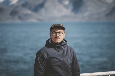 Kuzey Kutbu 'ndaki bir geminin güvertesinde durmuş gülümseyen yakışıklı genç adam. Grönland 'da Ilulissat' tan Nuuk 'a giden Sarfaq Ittuk kıyı gemisinde..