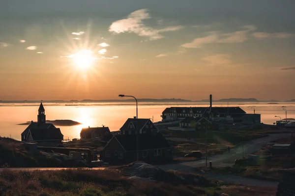 Gün doğumu gün batımı sırasında Ilulissat, Grönland Arktik şehir Havadan Görünümü. Turuncu pembe gökyüzü ile güneşli bir günde yaz aylarında arka planda buzdağları ile şehir merkezinde renkli evler — Stok fotoğraf