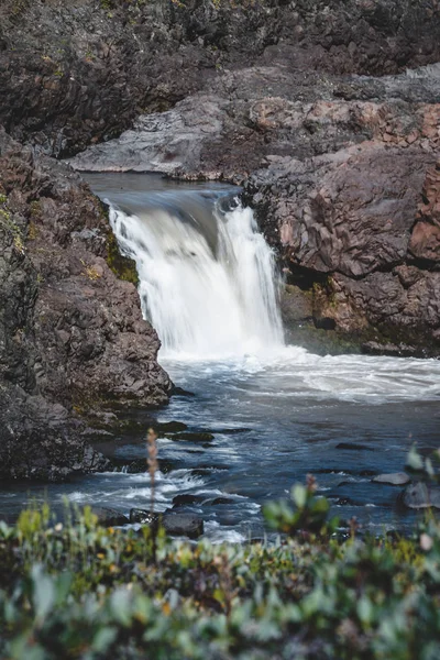 Closeup of a waterfall in a rocky environment on Island of kuannit, Disko Island in Greenland.