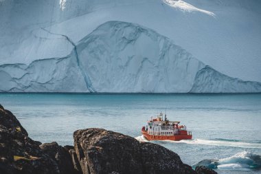 Turuncu balina arka planda buzdağları olan bir tur teknesi seyrediyor. Ilulissat 'taki Icefjord' a doğru bak. Grönland Disko Körfezi. Buzdağları bir yaz gününde güneş ışığını yansıtıyor.