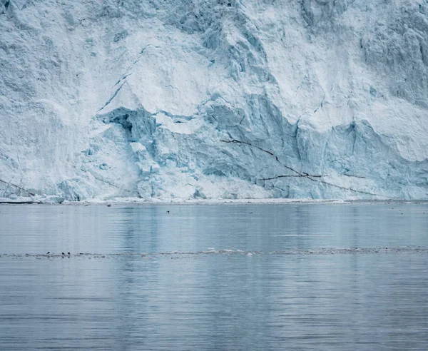 Close Up shot of huge Glacier wall. Large chunks of ice breaking off. Moody and overcast weather. Eqip Sermia Glacier called Eqi Glacier. Greenlandic ice cap melting because of global warming. — Stock Photo, Image