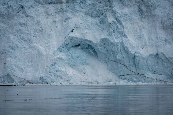 Primer plano de enorme pared glaciar. Grandes trozos de hielo rompiéndose. Clima húmedo y nublado. Glaciar Eqip Sermia llamado Glaciar Eqi. Derretimiento de la capa de hielo de Groenlandia debido al calentamiento global . —  Fotos de Stock
