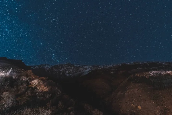 Escena del cielo nocturno con la Vía Láctea y estrellas sobre Marruecos en la cordillera del Alto Atlas entre Marrakech, Ait Ben Haddou y Ouarzazate. Montañas cubiertas de nieve y cielo oscuro . —  Fotos de Stock