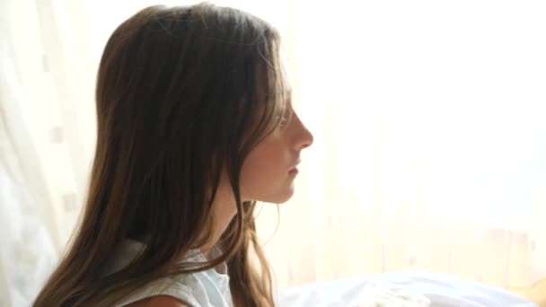 El video en cámara lenta de una chica cae sobre una almohada en su cama. 4k — Vídeo de stock
