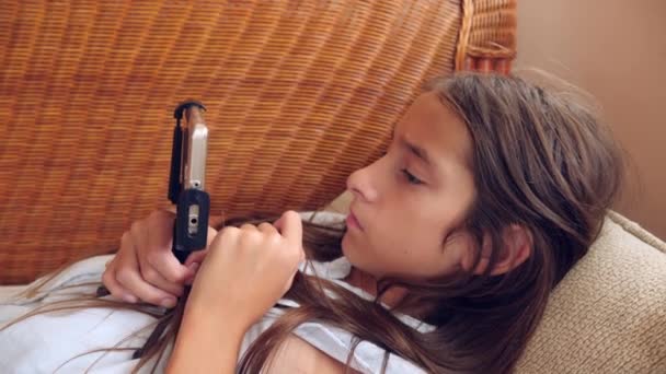 Fata stă întinsă pe canapea acasă, vorbind la telefon pe video. 4k, mișcare lentă — Videoclip de stoc