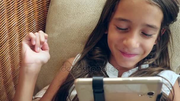 Het meisje is liggend op de Bank thuis, praten over de telefoon op video. 4k, slow-motion — Stockvideo
