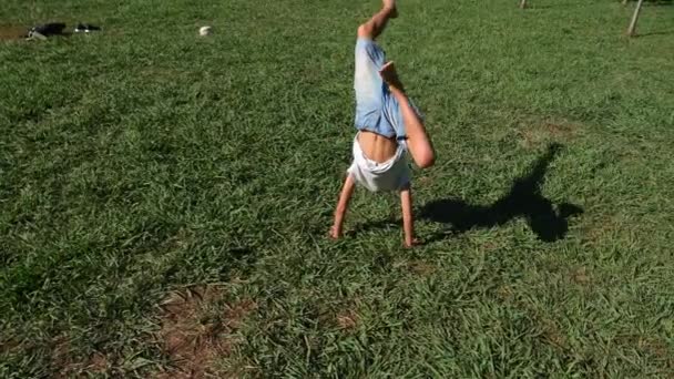 Divertido chico caucásico joven bailando sobre hierba verde al aire libre en verano día soleado. 4k, cámara lenta — Vídeo de stock