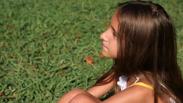 Malá holčička, 10 let, se nachází na zelené louce na letní slunečný den. detail. Zpomalený pohyb. 4k — Stock video