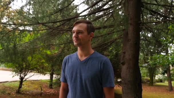 Jovem homem bonito andando na floresta, apreciando a natureza, 4k close-up, tiro em câmera lenta — Vídeo de Stock