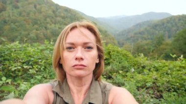 seyahat macera arkadaşlar paylaşım bir smartphone açık havada dağlar, bir arka plan üzerinde kullanarak görüntülü sohbet sahip kadın. Kız için sosyal medya selfie video çekimi. yavaş hareket 4k