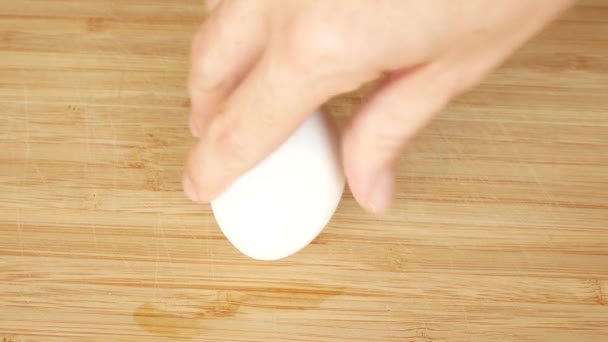 Uma pessoa transforma um ovo de galinha para ver se está cozido ou cru. o ovo cru vira lentamente. 4K. espaço para cópia — Vídeo de Stock
