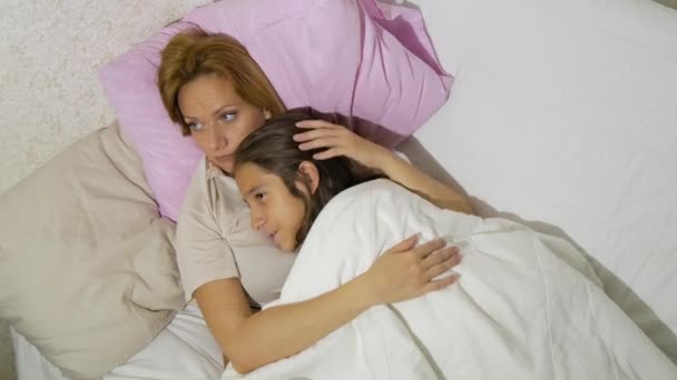 Madre e i suoi figli che parlano sdraiati a letto. 4k. copia spazio — Video Stock