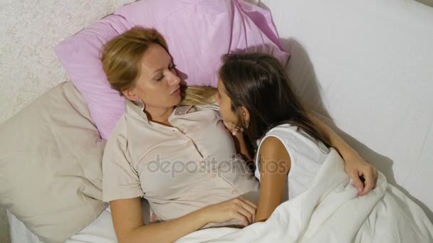 Moeder en haar kinderen praten in bed liggen. 4 k. kopie ruimte — Stockvideo