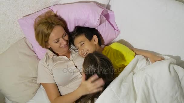 Mutter und ihre Kinder reden im Bett liegend. 4k. Kopierraum — Stockvideo