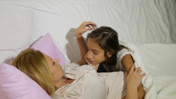 Mère et ses enfants parlent couchés au lit. 4k. espace de copie — Video