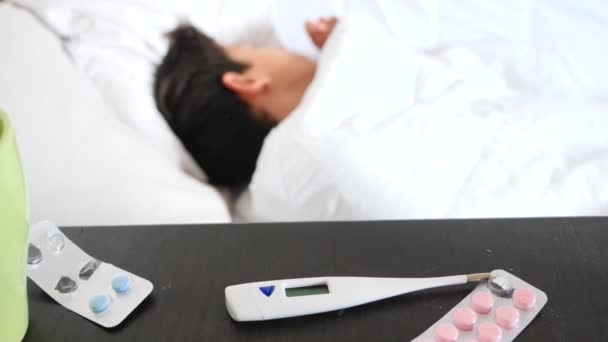 En sjuk pojke låg i sängen med feber. 4k, Slowmotion-skytte, kopiera utrymme — Stockvideo