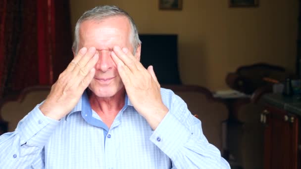 Retrato de cerca de un anciano, le duelen los ojos. 4k, cámara lenta — Vídeo de stock