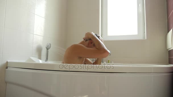 Jongeman, wassen van haar onder de douche. Man wast zijn haar thuis. 4k, slow-motion — Stockvideo