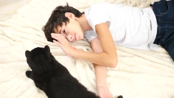 The boy hugs and strokes his pet, a black cat. 4k, slow motion — Stock Video