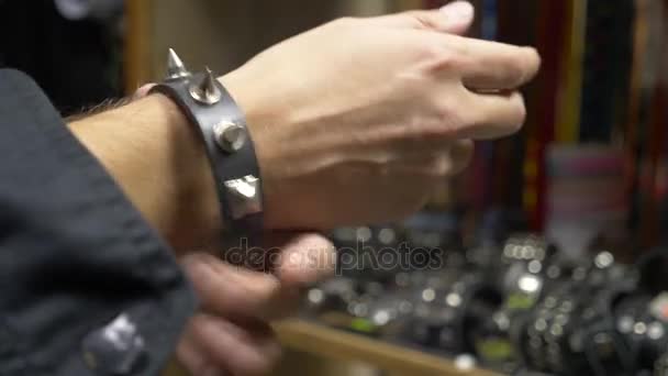 Urban Street Fashion. Black Hipster Outfit Trendy Clothes. shop of rock music. a man puts on a bracelet with spikes — Stock Video
