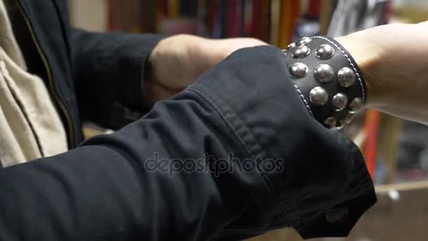 Urban Street Fashion. Black Hipster Outfit Trendy Clothes. shop of rock music. a man puts on a bracelet with spikes — Stock Video