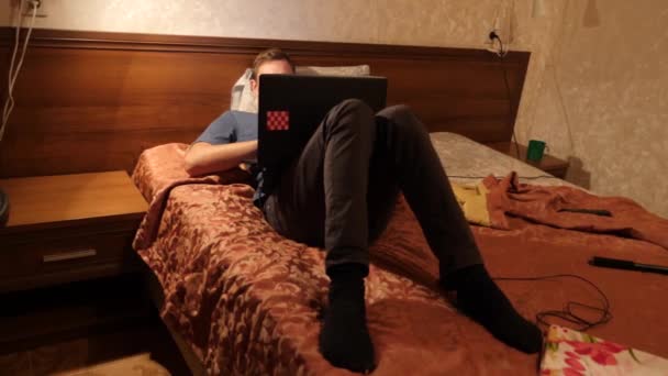 Homem sonolento com computador portátil na cama à noite. 4k — Vídeo de Stock