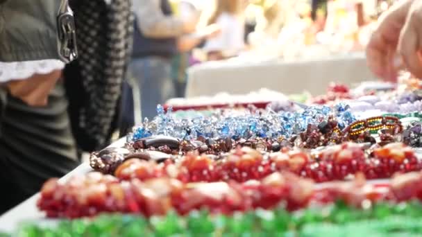 Vitrine avec des bijoux en pierres semi-précieuses. 4k, quelqu'un choisit les décorations. flou, gros plan . — Video