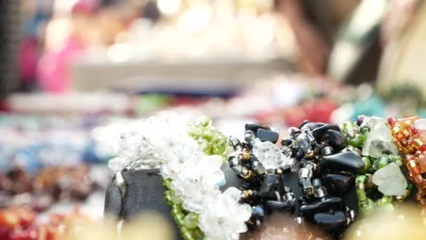 vitrine avec des bijoux en pierres semi-précieuses. 4k, quelqu'un choisit les décorations. flou, gros plan .