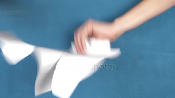 Ręce łzawienie arkuszu papieru, zbliżenie na turkus tło. 4k, zwolnionym tempie — Wideo stockowe