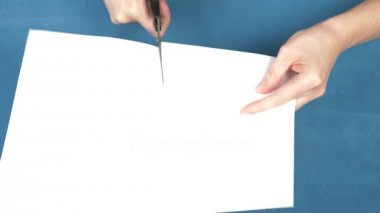 Eller makas yaprak kağıda, closeup turkuaz bir arka plan üzerinde kesme. 4k, ağır çekim