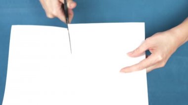 Eller makas yaprak kağıda, closeup turkuaz bir arka plan üzerinde kesme. 4k, ağır çekim