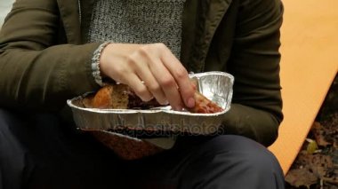 kadın ızgara sosis açık havada bir turist kampında yiyor. 4k,