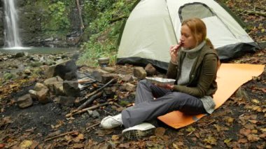 kadın ızgara sosis açık havada bir turist kampında yiyor. 4k,