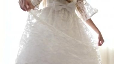 Yakın plan, 4K, yavaş çekim, kız beyaz dantelli bir elbise içinde dönüyor..