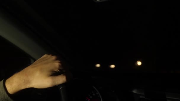 Hand aufs Lenkrad des Autos. Abends. Linksverkehr. 4k. Zeitlupe, verschwommenes Licht vor dem Fenster. — Stockvideo